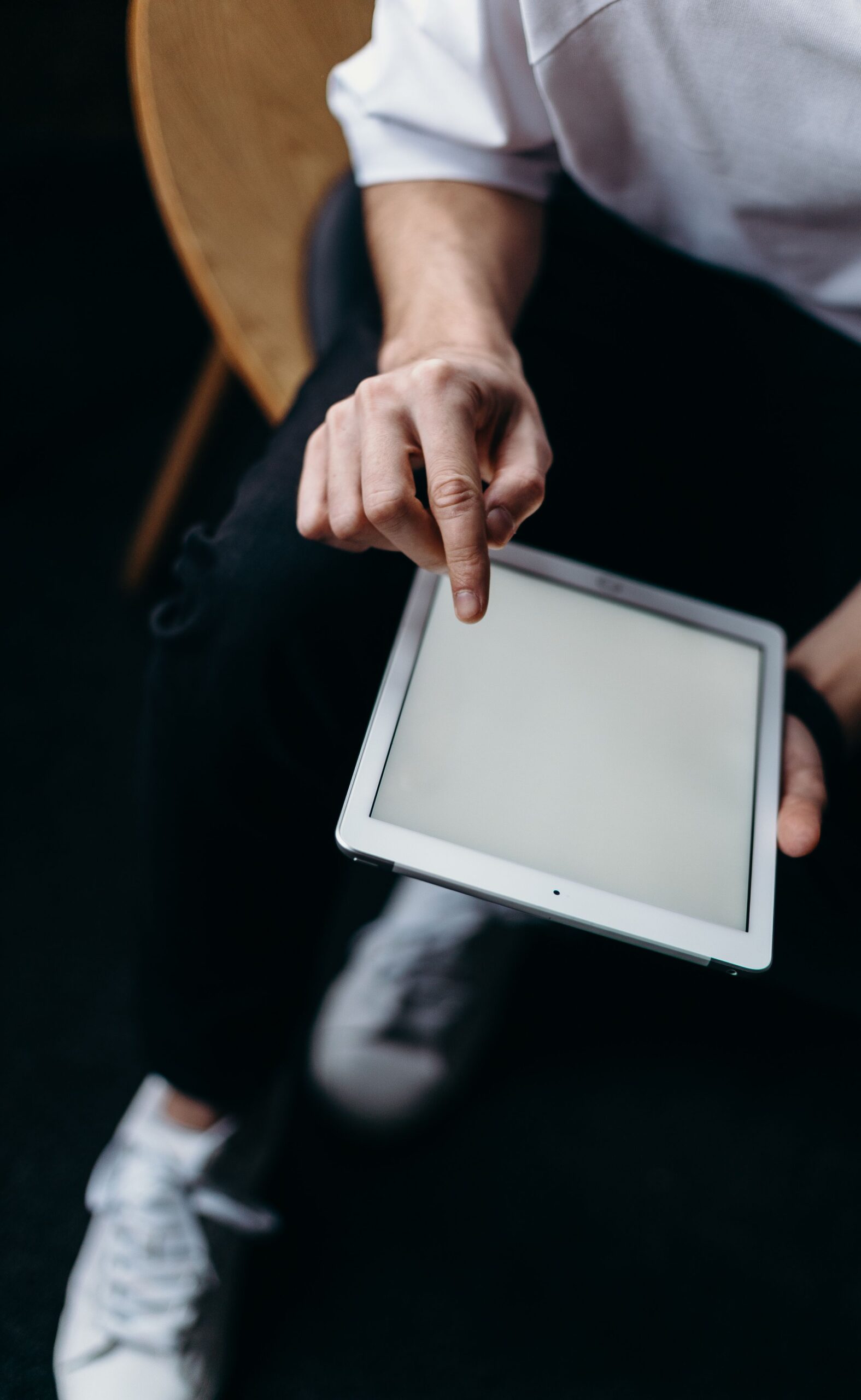 A person pointing at a tablet screen with copy space, ideal for tech and business uses.